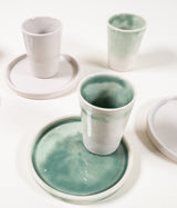 White ceramic shot glasses and matching plates